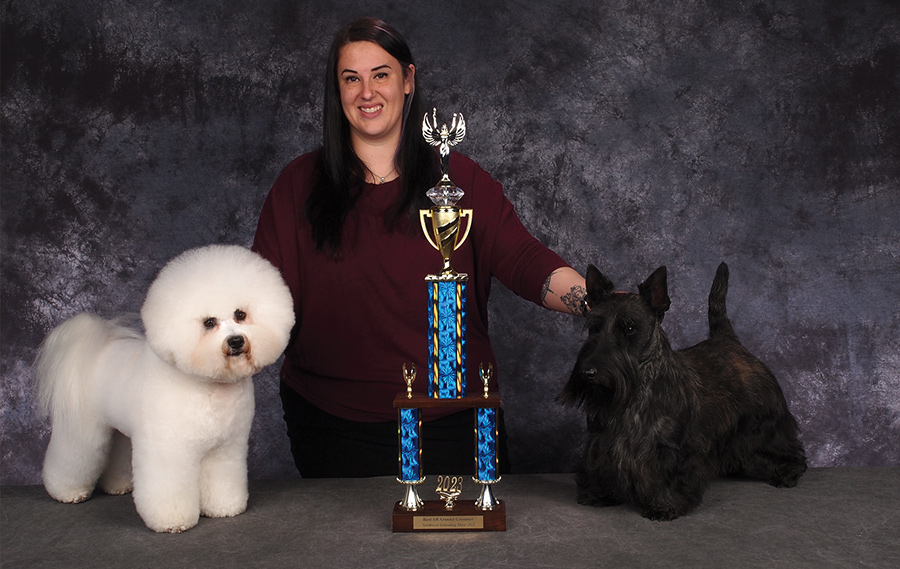 Lindsey Dicken posing with two dogs on a table