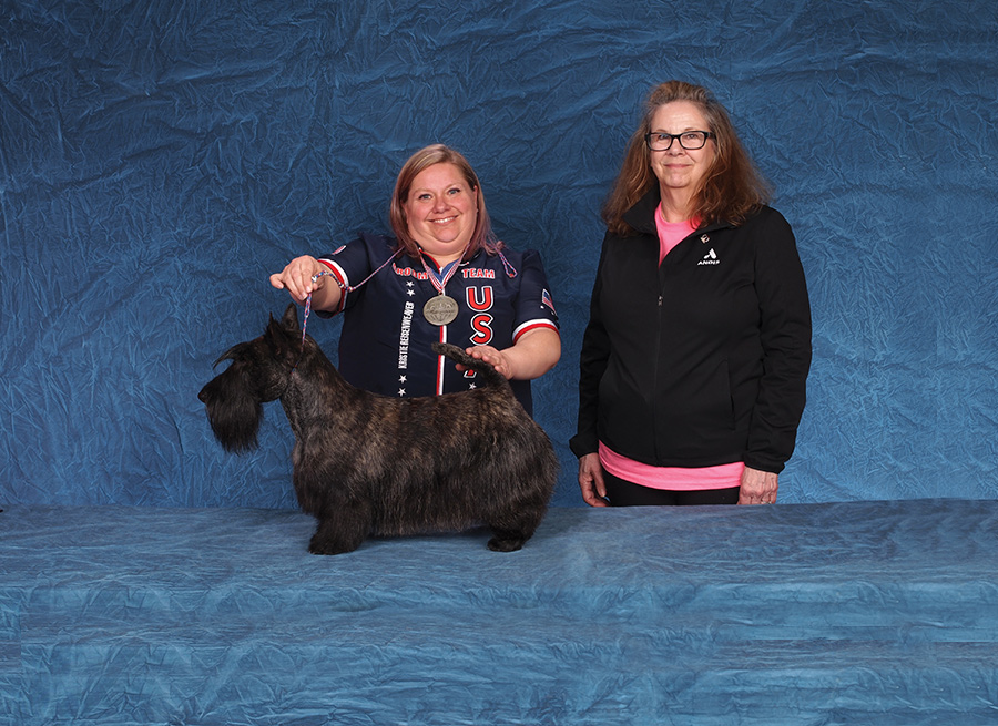 Kristie Reisenweaver with a black dog and their sponsor