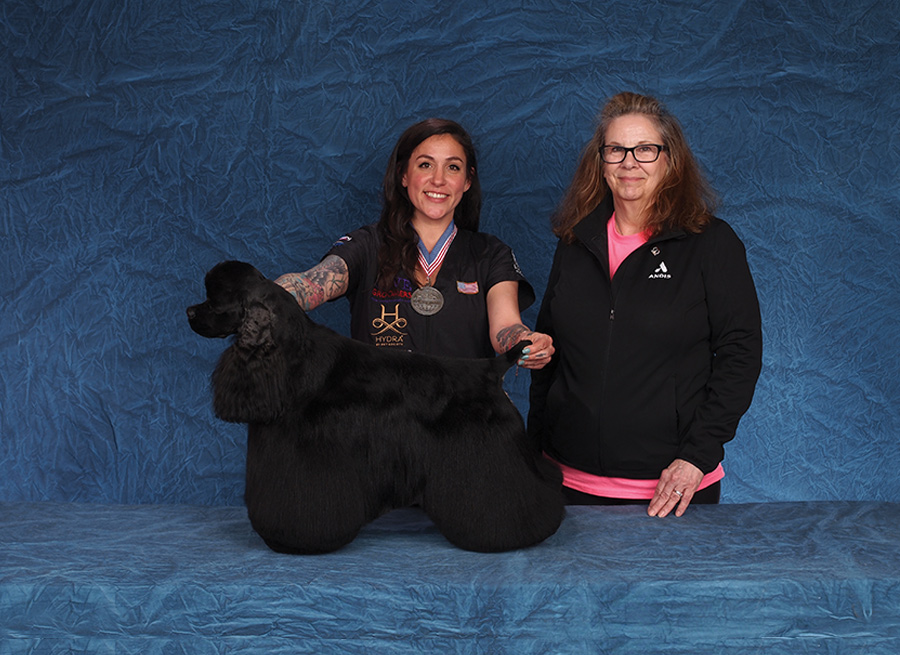 Mackensie Murphy with a black dog and their sponsor