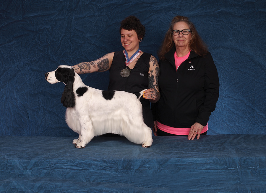 Nadia Bongelli with a black and white dog and their sponsor