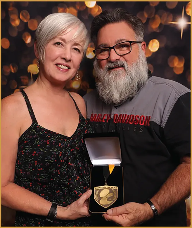 Ren & Lynn Netherland hold up an award together as they smile