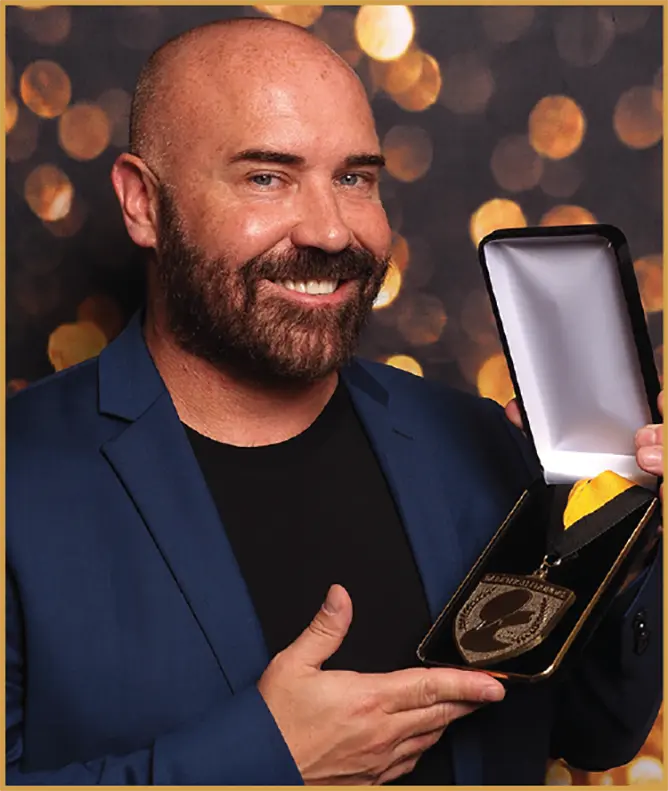 Jonathan David holds up an award as he smiles