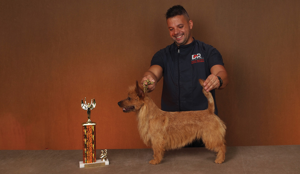 Manuel Martinez posing with a dog and a trophy