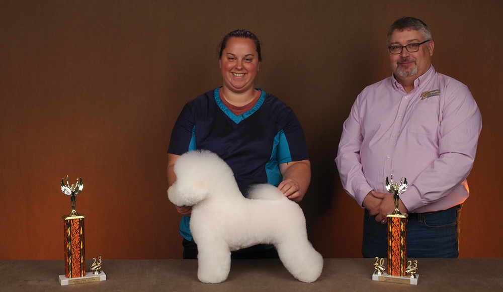 Courtney Crowley posing with a dog and a trophy