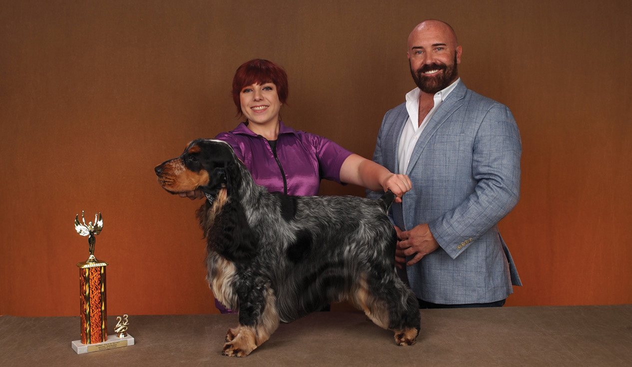 Amy Fluder posing with a dog and a trophy