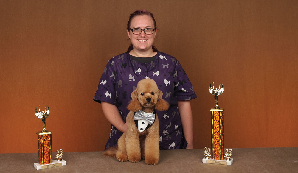 Allison Karel posing with a dog and a trophy