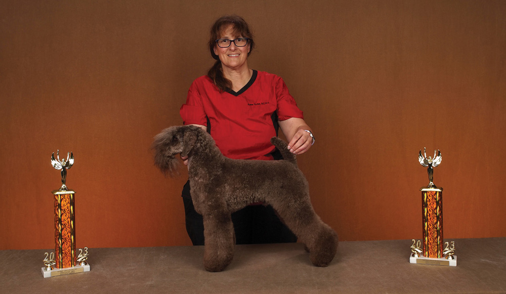 Karen Tucker posing with a dog and a trophy