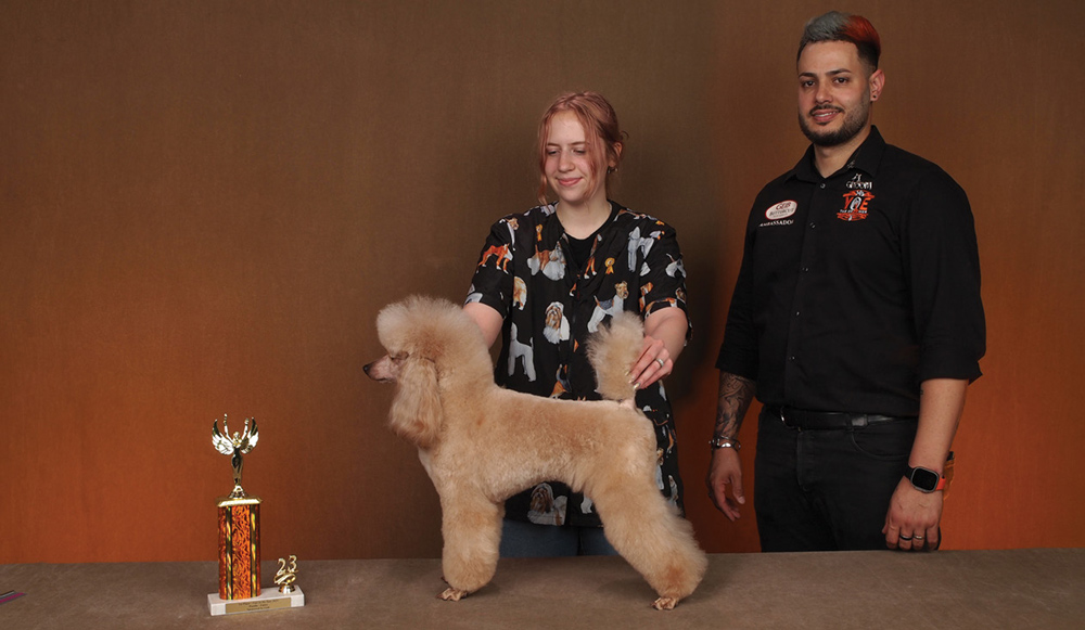 Amber Tudor posing with a dog and a trophy