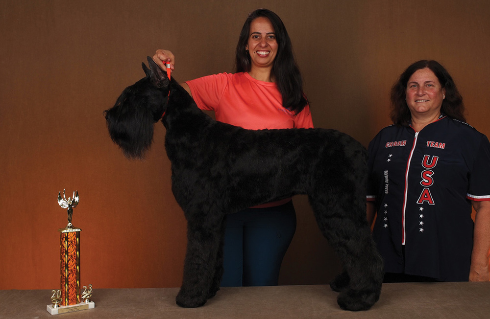 Elizabeth Machado posing with a dog and a trophy