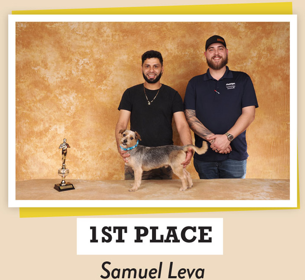 Samuel Leva posing with dogs and a trophy