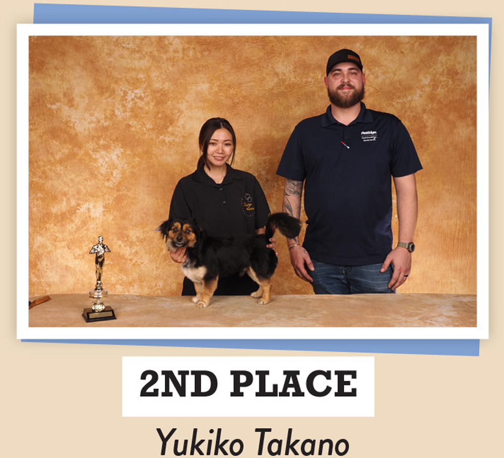 Yukiko Takano posing with dogs and a trophy