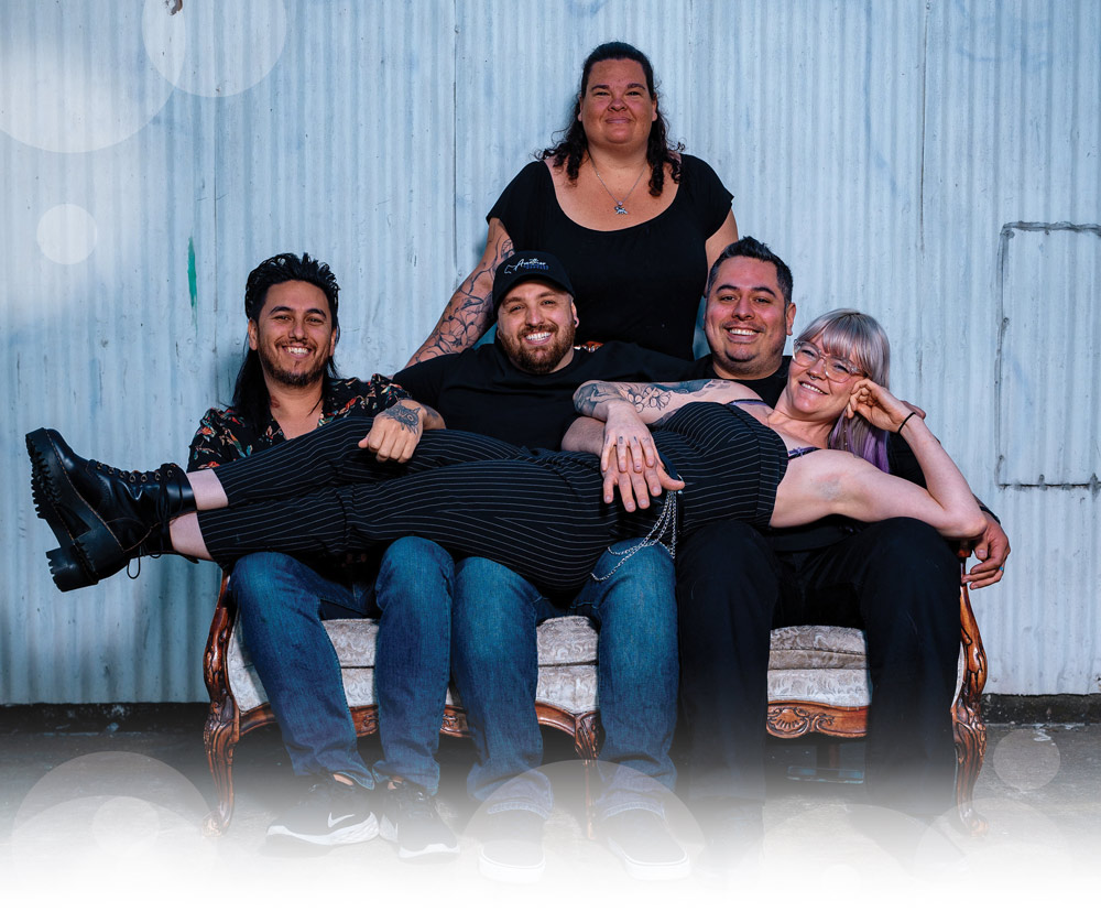 group of people taking a picture squeezed together on a small couch