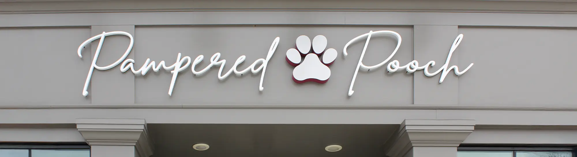 the exterior entrance signage of the Pampered Pooch boutique and salon