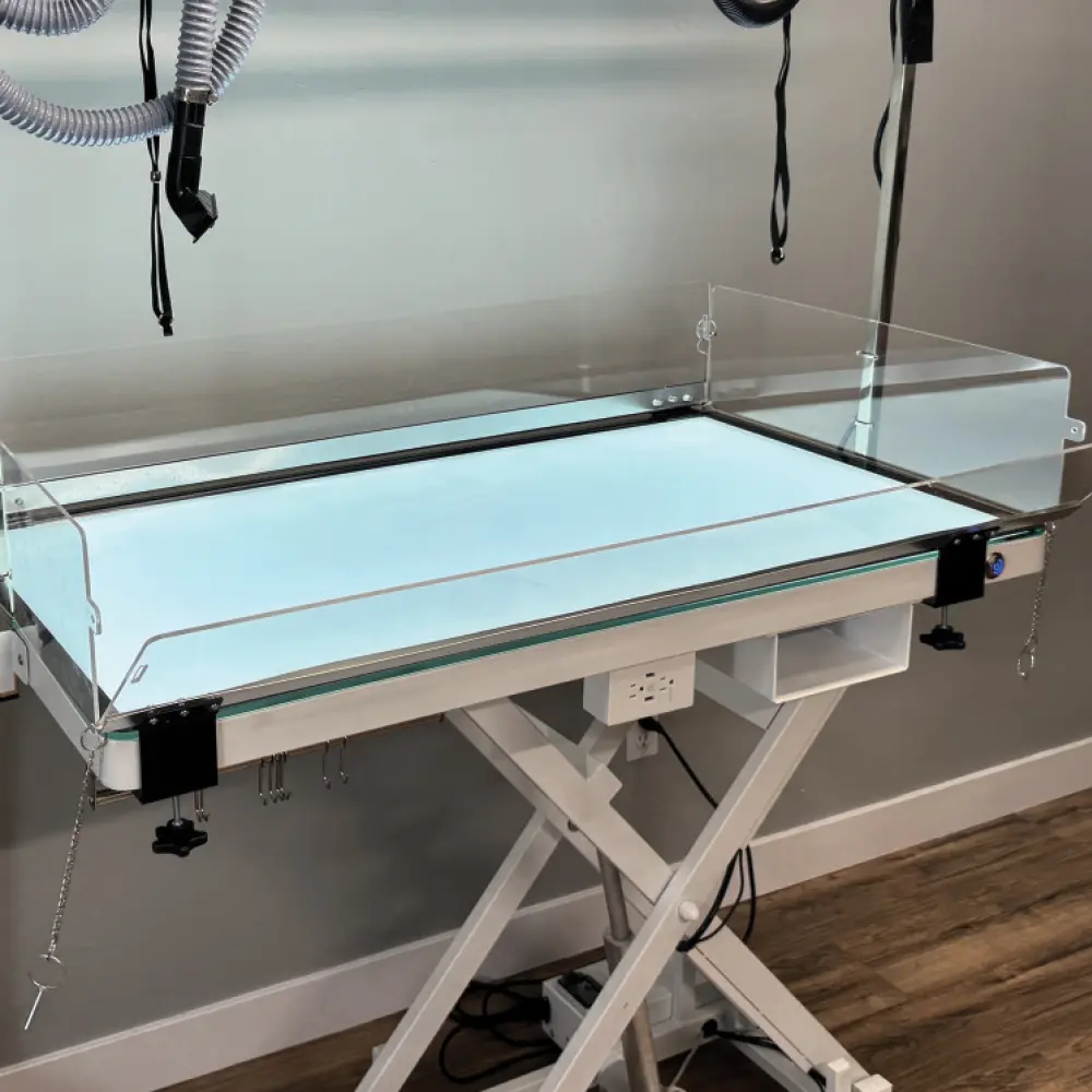 angled view of a grooming table in a salon room with a Groom Guard from K9 Kennel Store creating a barrier around the edges of the groom table