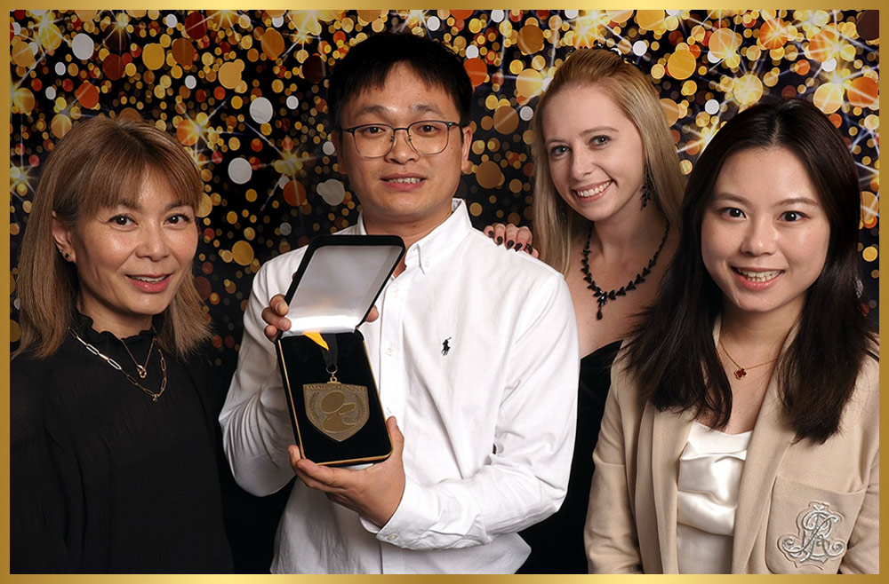 four Jirpet representatives take a group photo as the man in center holds a medal in a presentation box
