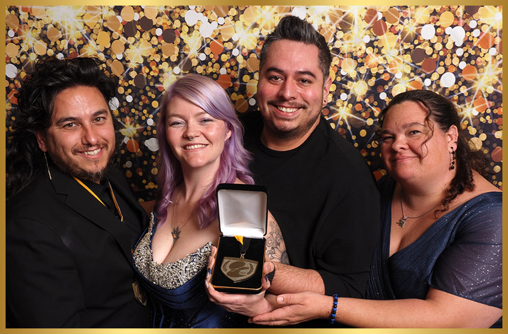 Another Grooming Podcast representatives take a group photo while holding a medal in a presentation box