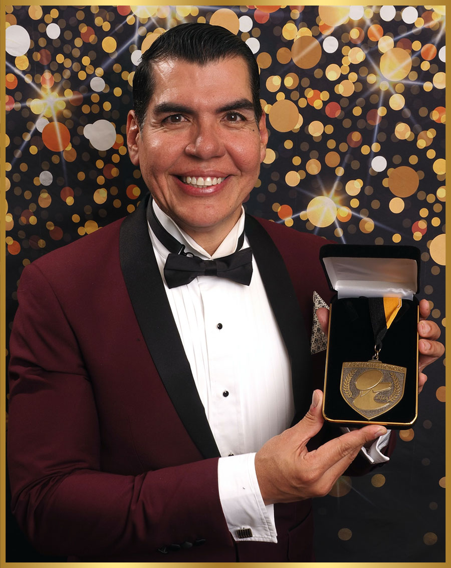 Victor Rosado pictured holding a medal in a presentation box