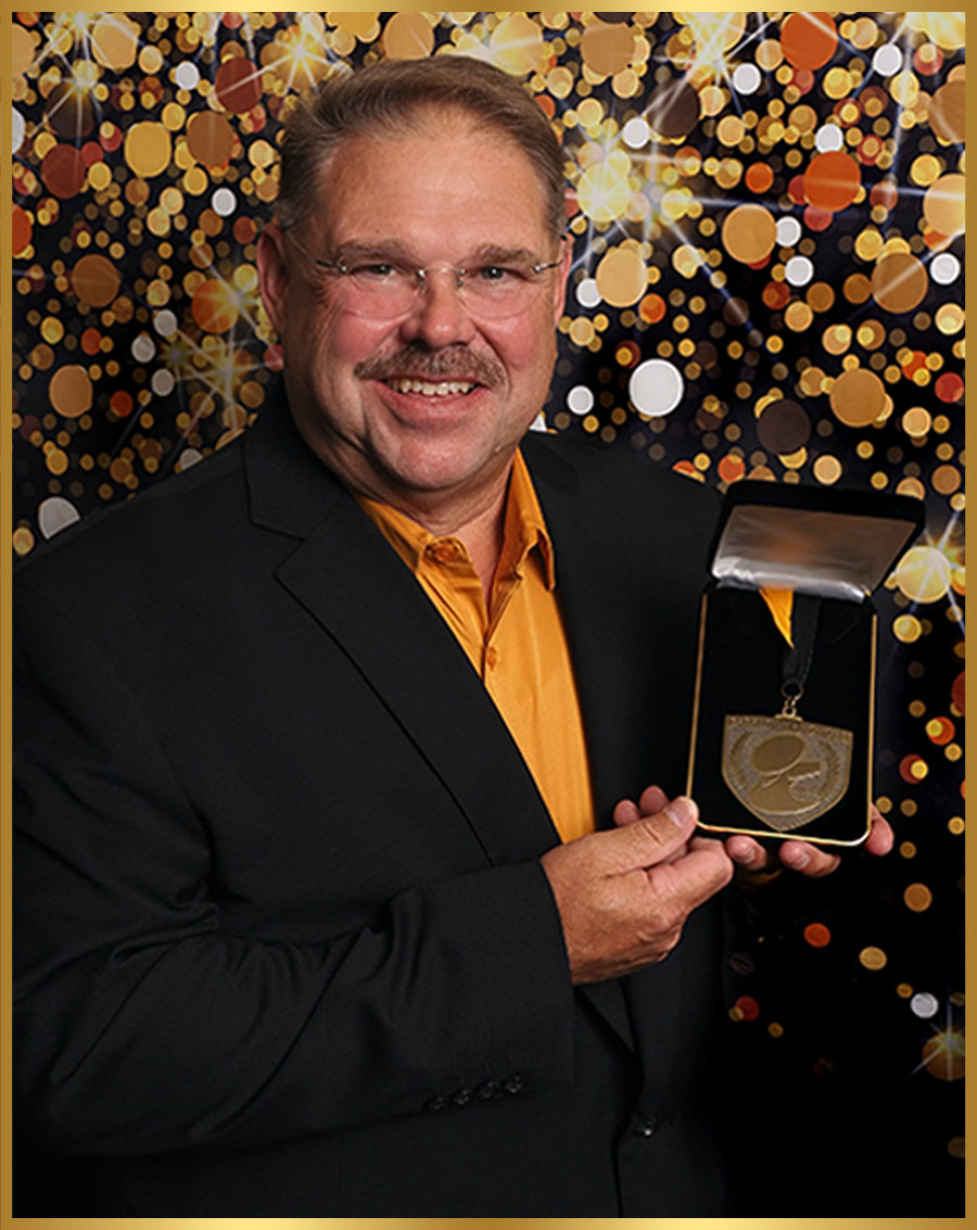 Tom Stockstill pictured holding a medal in a presentation box