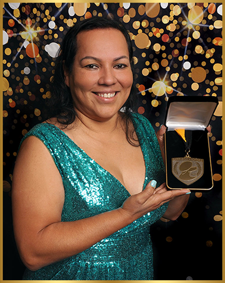 Milena Kon pictured holding a medal in a presentation box
