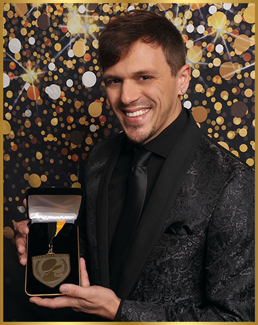 Evan Gummo pictured holding a medal in a presentation box