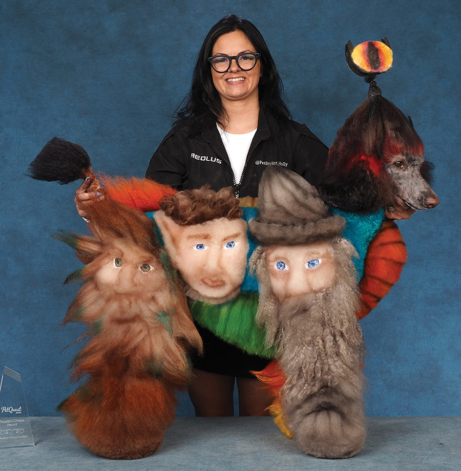 A groomer holds a Standard Poodle displaying the opposite side's Lord of the Rings creative grooming designs.